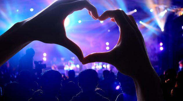 Crowd of Audience at during a concert with a heart shaped hands shadow